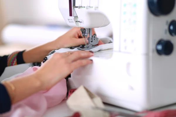 Young woman sewing while sitting at her working place — Stock Photo, Image