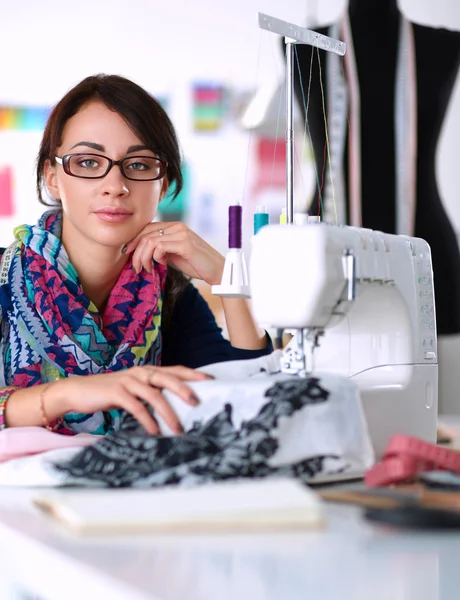 Mujer joven cosiendo sentado en su lugar de trabajo — Foto de Stock