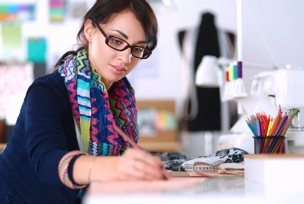 Dressmaker designing clothes pattern on paper — Stock Photo, Image