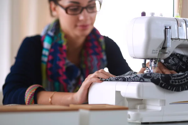 Young woman sewing while sitting at her working place — Stock Photo, Image