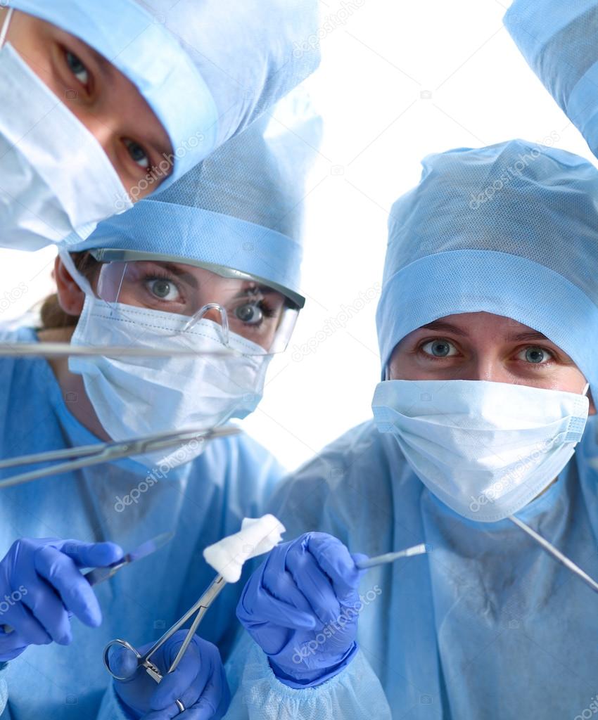 Below view of surgeons holding medical instruments in hands