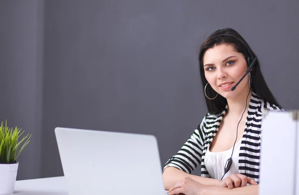 Piękna kobieta biznesu pracuje przy biurku ze słuchawkami i laptopem — Zdjęcie stockowe