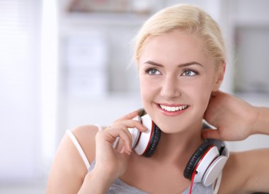 Evdeki genç ve güzel kadın kanepede oturup müzik dinliyor.