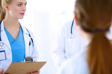 Kadın doktor hastanede dosyayla bekliyor.