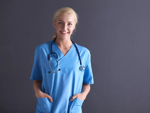 Jovem médica com estetoscópio isolado em fundo cinza — Fotografia de Stock