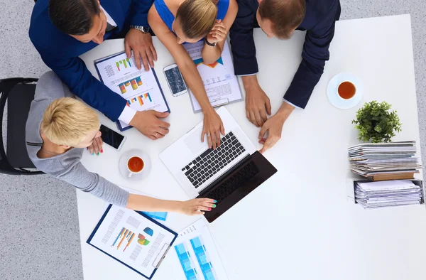 Bovenaanzicht van een team van kantoorpersoneel wijzend op een laptop — Stockfoto