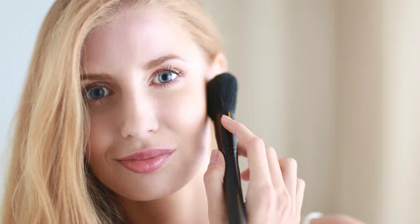 Pretty woman applying make up with brush — Stock Photo, Image