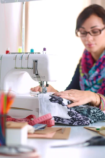 Jeune femme couture assis à son lieu de travail — Photo