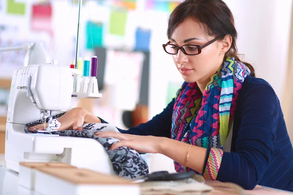 Jeune femme couture assis à son lieu de travail — Photo