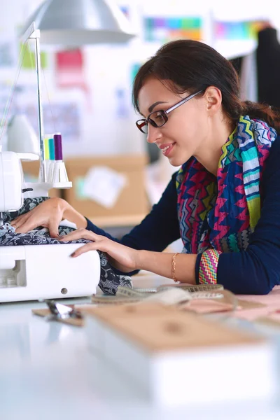 Mujer joven cosiendo sentado en su lugar de trabajo —  Fotos de Stock