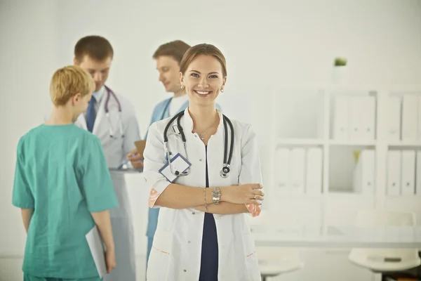 Felice medico con i suoi colleghi sullo sfondo — Foto Stock