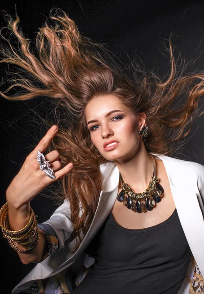 Portrait of young woman with beads, standing on black background — Stock Photo, Image