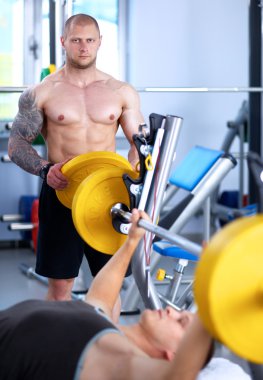 Pazı gerçekleştirme genç bir adam çekim bir spor salonunda bukleler
