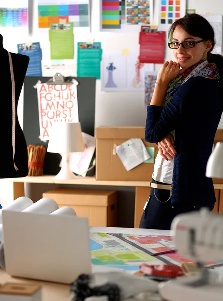 Schöne Modedesignerin steht im Atelier — Stockfoto