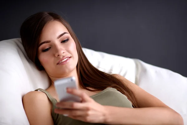 Pretty woman in her living room lying on the couch sending mess — Stock Photo, Image