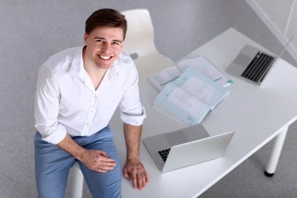 Young businessman working in office, sitting at desk — Stock Photo, Image