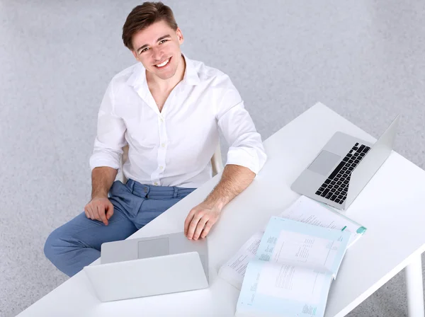 Mladý podnikatel pracující v kanceláři, sedí za stolem — Stock fotografie
