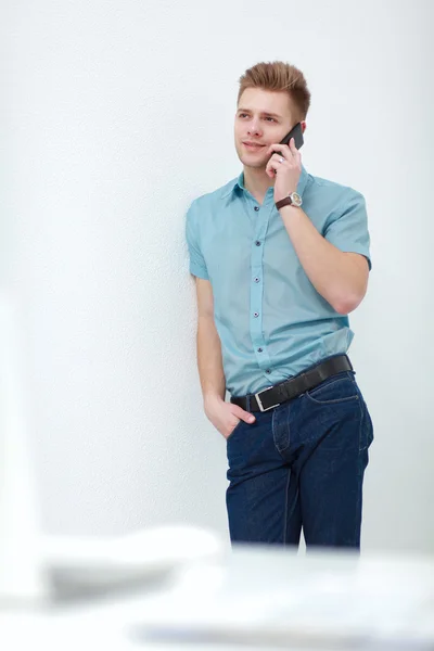 Портрет гарного впевненого молодого бізнесмена, який розмовляє по телефону — стокове фото