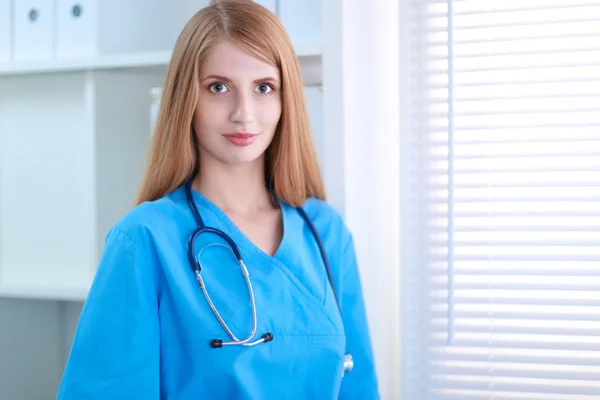 Doctor  woman is standing in the near window — Stock Photo, Image