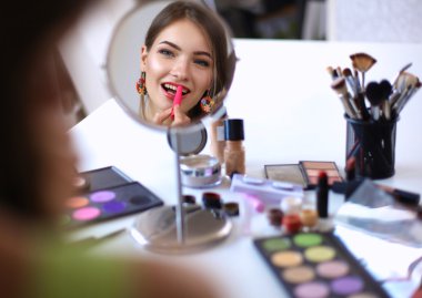 Genç güzel kadın ayna, Masa başında oturan yakınındaki makyaj yapma