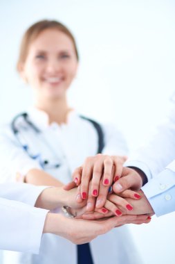 Doktorlar ve hemşireler tıbbi bir ekipte el ele tutuşuyorlar.