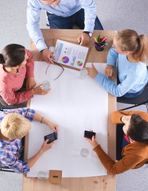 İş adamları iş toplantısında, ofiste oturup tartışıyorlar.