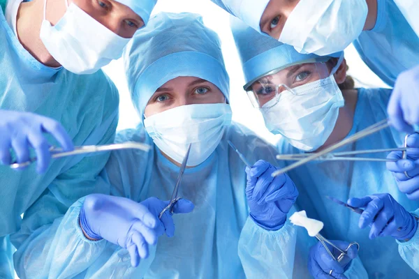 Below view of surgeons holding medical instruments in hands — Stock Photo, Image