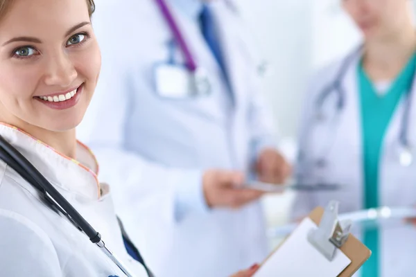 Belle jeune femme médecin souriante assise au bureau — Photo