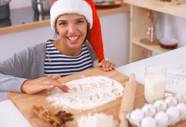 Happy young woman smiling happy having fun with Christmas preparations wearing Santa hat — Stock Photo, Image