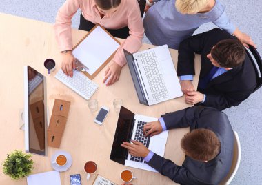 İş adamları iş toplantısında, ofiste oturup tartışıyorlar.