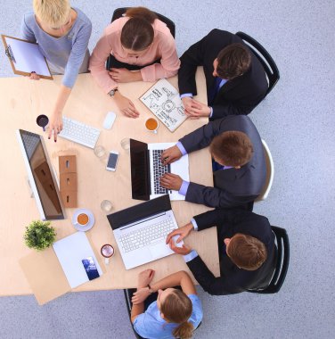 İş adamları iş toplantısında, ofiste oturup tartışıyorlar.