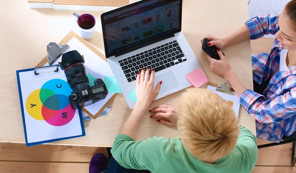 Female photographer sitting on the desk with laptop — Stock Photo, Image