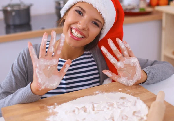 Mutlu genç bayan gülümsüyor Noel hazırlıklarıyla eğleniyor Noel Baba şapkası takıyor. — Stok fotoğraf