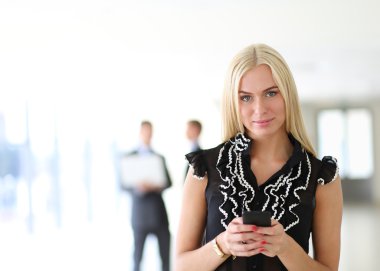 Ofiste cep telefonu kullanan güzel bir iş kadını.