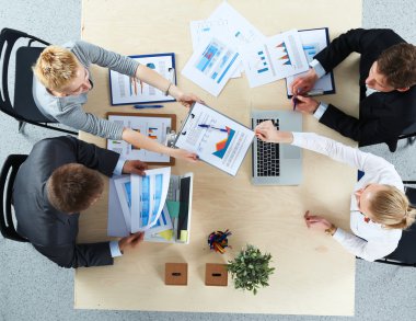 İş adamları iş toplantısında, ofiste oturup tartışıyorlar.