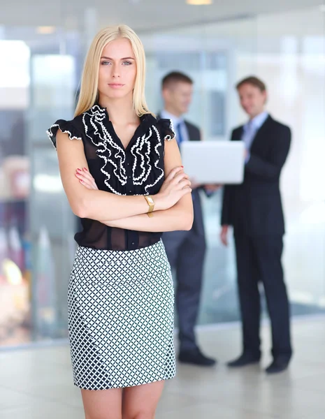 Zakenvrouw permanent op voorgrond in office — Stockfoto