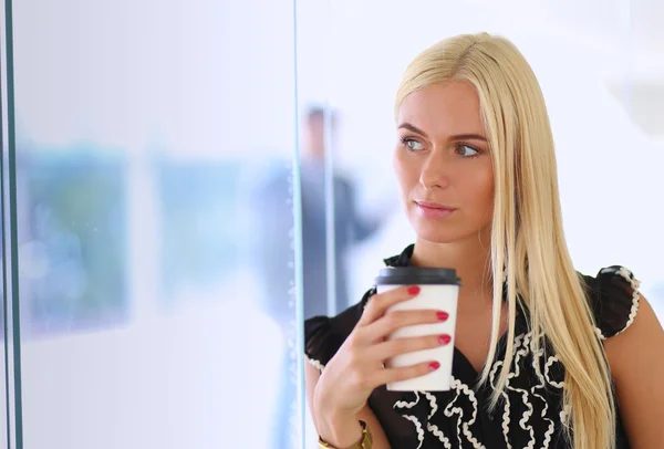 Empresaria sosteniendo una taza de café de pie en la oficina —  Fotos de Stock