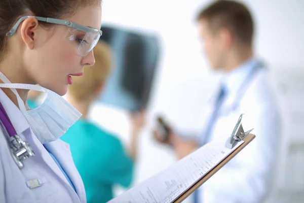 Woman doctor standing with folder at hospital — Stock Photo, Image