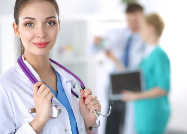 Woman doctor standing with folder at hospital — Stock Photo, Image