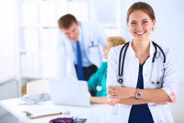 Kadın doktor hastanede steteskopla dikiliyor.