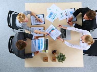 İş adamları iş toplantısında, ofiste oturup tartışıyorlar.