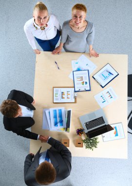 İş adamları iş toplantısında, ofiste oturup tartışıyorlar.