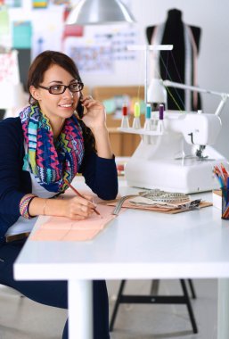 Giysi tasarımcısı kağıt üzerinde kıyafet deseni tasarlıyor