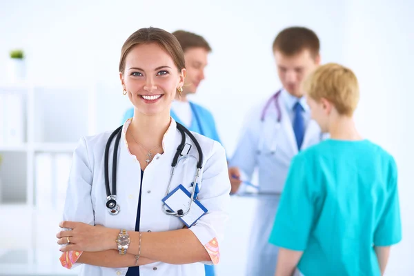 Attractive female doctor in front of medical group — Stock Photo, Image