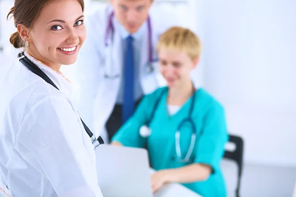 Médica atraente na frente do grupo médico — Fotografia de Stock