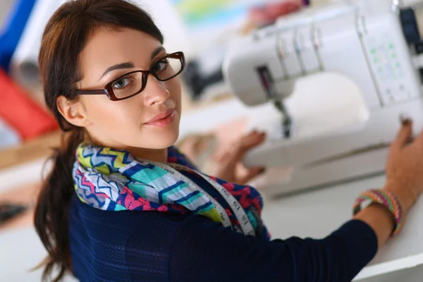 Jeune femme couture assis à son lieu de travail — Photo