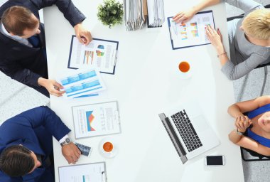 İş adamları iş toplantısında, ofiste oturup tartışıyorlar.