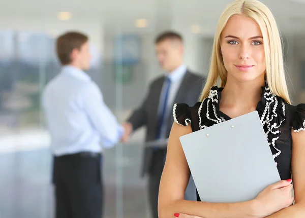 Business woman standing in foreground  in office — Stock Photo, Image