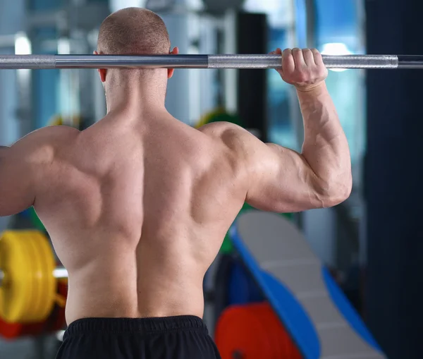 Bodybuilder met barbell in gym — Stockfoto