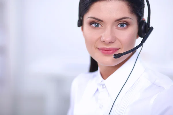 Portrait of beautiful businesswoman working at her desk with headset and laptop — Stock Photo, Image